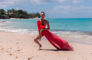 Tropik bir plajda kırmızı bikini giyen ve giyinen bir kadın. Barbados, Karayip Denizi 'ndeki uzak tropik plajlar. Sade. Portre.