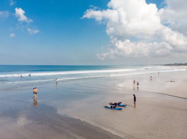 Endonezya, Bali 'deki Low Tide Beach. Badung Şehri. Arkaplanda Okyanus Suyu ve Turistler. Turistler ve Yerel Halkın Popüler Beneği.