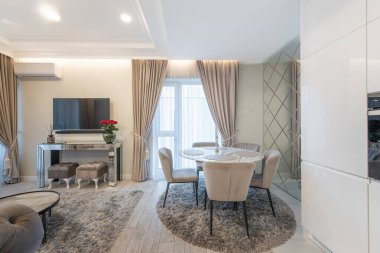 Modern Oturma Odası İçi. Yemek masası arka planda. Lüks mobilyalar. Televizyon ekranı. Gül Çiçekleri vazosu. Sağ taraftaki ayna. Ev