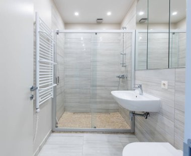 Parlak Zarif Modern Minimalist Banyo Beyaz Lavabolu Duş Odasının İç Tasarımı. Banyo aksesuarları, Gri Duvarlar, Beton Döşeme, Ayna