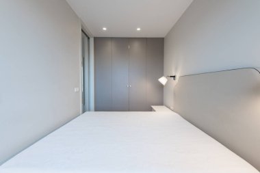 Minimalizm yatak odası iç mimarisi. Arka plandaki gardırop. Kahve Masası ve Hafif.