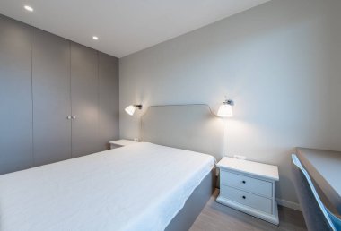Minimalizm yatak odası iç mimarisi. Arka plandaki gardırop. Kahve Masası ve Hafif.