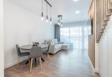 Lüks Oturma Odası İçi. Modern Geniş TV Ekranı. Kanepe, Masa Sandalyeleri ve Tavanda LED Işık.