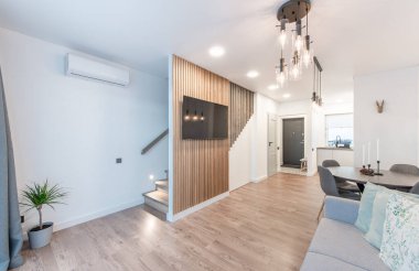 Lüks Oturma Odası İçi. Modern Geniş TV Ekranı. Kanepe, Masa Sandalyeleri ve Tavanda LED Işık.