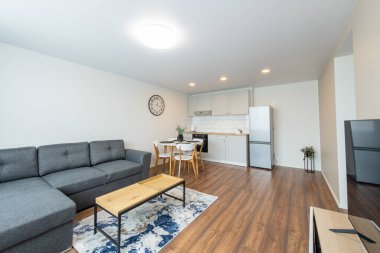 Modern Ev Oturma Odası ve Mutfak İçi. Lüks modern apartman dairesi. İç mekan, Mobilya, Beyaz Mobilya, İskandinav Tasarımı. Önplanda TV Ekranı.