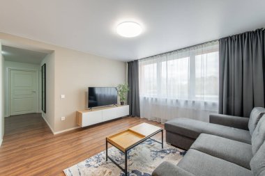 Modern Ev Oturma Odası İçi. Lüks modern apartman dairesi. Açık iç mekan, stil koltuğu, kahve masası, İskandinav tasarımı. TV Ekranı, Pencereler ve Perdeler.