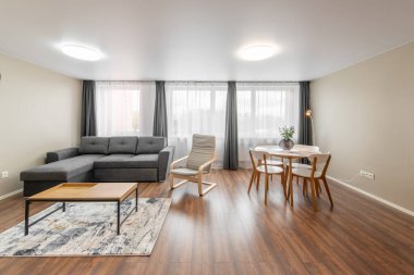 Modern Ev Oturma Odası İçi. Lüks modern apartman dairesi. Açık Alan, Şık Koltuk, Kahve Masası, İskandinav Tasarımı. Pencereler ve Perdeler. Yerde halı var.