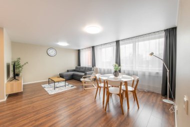 Modern Ev Oturma Odası İçi. Lüks modern apartman dairesi. Açık Alan, Şık Koltuk, Kahve Masası, İskandinav Tasarımı. Pencereler ve Perdeler. Yerde halı var.