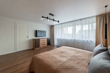 Lüks yatak odası iç mekan, modern ev, güzel iç mekan, geniş yatak odası. Duvardaki TV seti. Beyaz Çıkış Kapısı