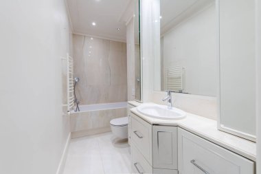 Parlak Modern Lüks Banyo Beyaz Lavabolu Duşun İç Tasarımı. Beyaz Duvarlar, Ayna ve Musluk. LED ışıkları. Geniş Açı