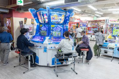 Nakano, Japonya - 26 Mayıs 2024: İnsanlar bir Japon atari salonunda Pachinko oynuyor. Kumar makinesi