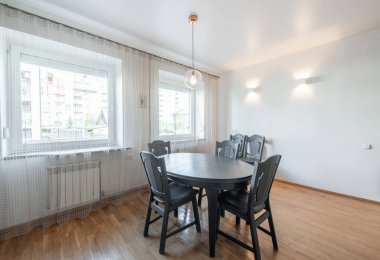 Klasik Beyaz Mutfak İçi ve Yemek Masası. Fırın, çaydanlık, mikrodalga ve cam. Tabaklar masanın üzerinde. Asgari İç Tasarım.