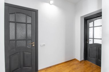 Evdeki Kara Klasik Tahta Kapı. Beyaz Duvarlar, iç mekan. Yatak odası ve tuvaletin kapısı.