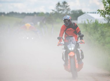 Moto ekipmanlı profesyonel bir motosikletçi. Doğada dayanıklı bisiklet sürüyor. Sürücü çakıllı yolda, motosiklet yarışında. Off-road turnuvası. Ormanda dayanıklı sporlarda motosikletliler