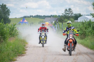 Moto ekipmanlı profesyonel bir motosikletçi. Doğada dayanıklı bisiklet sürüyor. Sürücü çakıllı yolda, motosiklet yarışında. Off-road turnuvası. Ormanda dayanıklı sporlarda motosikletliler