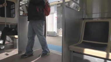 Chicago, Illinois 'deki Metro Treni. Tren istasyona varır. İnsanlar trene binip iniyor.
