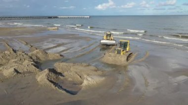 Plaj restorasyonu ve buldozerler. Denizin götürdüğü sahilin yeniden inşası için kazıcıyla birlikte borudan çamur akıyor. Plaj besinleri için çalışmalar devam ediyor. Drone Hava Çekimi