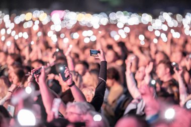 Konserde akıllı telefonla fotoğraf çeken biri.