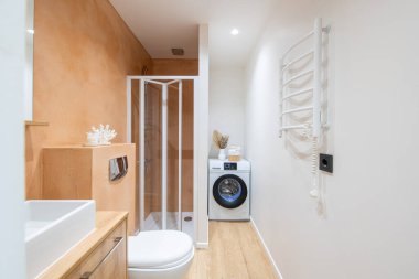 Beyaz Lavabolu Parlak Modern Lüks Banyo İç Tasarımı. Pembe Renkli Duvarlar, Ayna ve Musluk. LED ışıkları. Çamaşır makinesi. Duş kabini, ısıtıcı. Geniş Açı