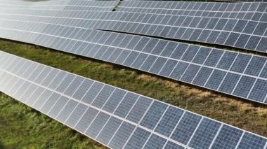 Sıra sıra fotovoltaik paneller. Yenilenebilir enerji oluştur. Drone bakış açısı. Güneş enerjisi santrali panelleri. Fields Green Energy Sunset 'te. Elektrik Güç Ekolojisi ortamı. Elektrik İnovasyonu. 4k