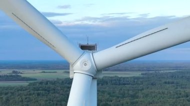 Rüzgar türbinlerinin hava görüntüleri zarifçe dönüyor ve daha fazla rüzgar türbini bulunuyor. Kıyıdaki ve tarımdaki sürdürülebilir sinerji. Güzel bir manzara. Altın Saat. 4k
