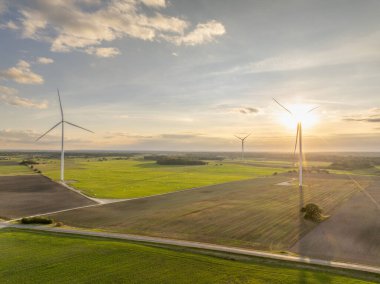 Rüzgar Türbini Rüzgar Parkı. Hava Aracı Görünümü. Uzakta daha fazla rüzgar türbini olan hava aracı görüş noktası. Kıyıdaki ve tarımdaki sürdürülebilir sinerji. Güzel bir manzara. Altın Saat.