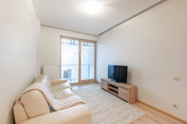 Modern Ev Apartmanı Salonu. Lüks modern apartman dairesi. İskandinav Tasarımı. TV ekranındaki kanepe. Halı. Pencereler ve LED Işık. Geniş Açı