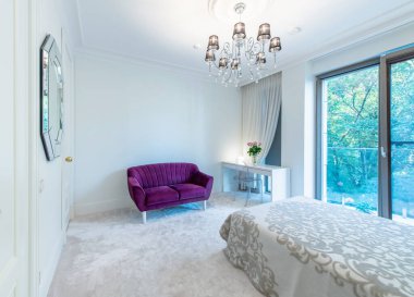 Lüks yatak odası iç mimarisi, modern ev, güzel iç mekan, büyük boy yatak. Pencereden Balkon 'a, Mor Koltuk ve Masa' ya. Duvardaki Ayna. Geniş Açı