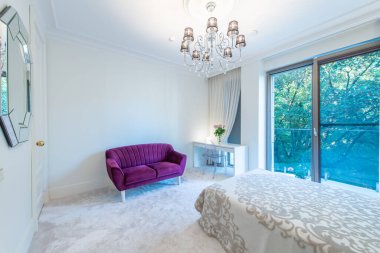 Lüks yatak odası iç mimarisi, modern ev, güzel iç mekan, büyük boy yatak. Pencereden Balkon 'a, Mor Koltuk ve Masa' ya. Duvardaki Ayna. Geniş Açı