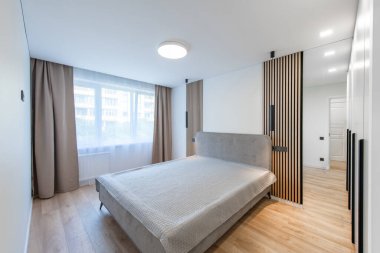 Geniş Ev Yatak Odası İçi Açısı. Arka planda büyük boy çift kişilik yatak ve gardırop. Beyaz Duvarlar. Aile Evi. Pencereler ve Perdeler. Parlak Güneşli Gün