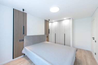 Geniş Ev Yatak Odası İçi Açısı. Arka planda büyük boy çift kişilik yatak ve gardırop. Beyaz Duvarlar. Aile Evi. Kapalı Beyaz Tahta Kapı. Parlak Güneşli Gün