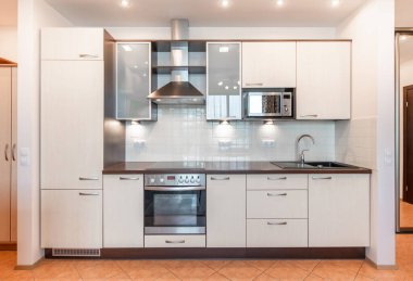 İskandinav Tarzı Konforlu Modern Açık Parlak Mutfak İç mimarisi. Arka planda musluk, buzdolabı, mikrodalga fırın, fırın, fırın, kaput ve mobilya var. Geniş Açı