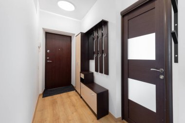 Parlak ve işlevsel koridorda koyu ahşap kapılar, eşleşen mobilyalar, palto kancaları ve aydınlık duvarlar ve çağdaş bir iç tasarım için döşemeler ile tamamlanmış depo alanları yer almaktadır..