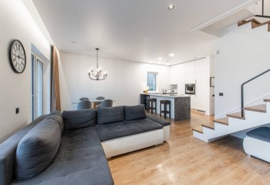 Modern mobilyalar, bir merdiven ve şık renklerde şık ve davetkar ev ortamları için modern açık alan oturma odası ve mutfak tasarımı..