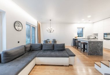 Modern mobilyalar, bir merdiven ve şık renklerde şık ve davetkar ev ortamları için modern açık alan oturma odası ve mutfak tasarımı..