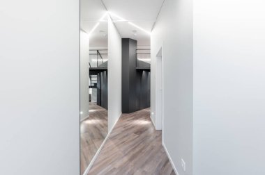 Temiz çizgiler, geometrik mimari, zarif ahşap döşeme, minimalist ve stil sahibi modern minimalist Modern Minimalist Lüks Ev Koridoru 'nun yer aldığı çağdaş bir koridor.