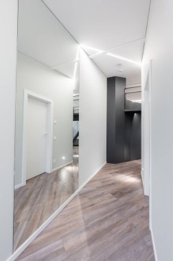 Temiz çizgiler, geometrik mimari, zarif ahşap döşeme, minimalist ve stil sahibi modern minimalist Modern Minimalist Lüks Ev Koridoru 'nun yer aldığı çağdaş bir koridor.