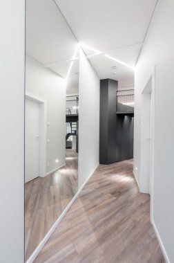 Temiz çizgiler, geometrik mimari, zarif ahşap döşeme, minimalist ve stil sahibi modern minimalist Modern Minimalist Lüks Ev Koridoru 'nun yer aldığı çağdaş bir koridor.