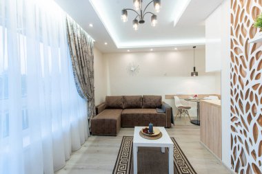 Konforlu bir oturma odası, çağdaş ışıklandırma ve karmaşık dekoratif bir bölme içeren şık bir ev. Modern mobilya ve ev dekorasyonu sergilenen zarafet ve konforun karışımı..
