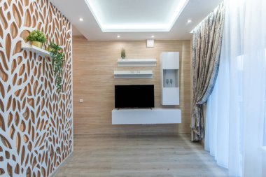 Ahşap bir aksan duvarı, monte edilmiş TV, şık dekor unsurları, desenli perdeler, rahat ve davetkar bir ev için cazip bir tasarım içeren çağdaş bir oturma odası. Modern Ev Oturma Odası