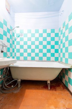 Turkuaz ve beyaz kareli parlak bir banyo ve neşeli renk düzeniyle canlı bir atmosfer yaratan klasik beyaz bir küvet. Ayarlar basitlik ve minimalizmi gösteriyor..