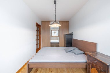 Eski Retro Style Ev Yatak Odası İçi. Aynalı Gardırop Dolapları, Çekmeceler Sandığı, Pencereler, Isıtıcı ve Lamba. Beyaz Tavan ve Duvarlar. Büyük boy yatak ve ahşap kapı. Geniş Açı