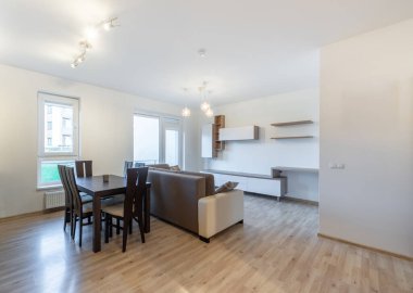 Kanepesi, yemek masası ve şık mobilyaları olan bir oturma odası olan parlak ve ferah bir modern iç mekan. Moda Aydınlatma ve Mobilyalı Modern Açık Konsept Oturma ve Yemek Odası