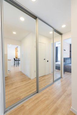 Parlak ve geniş kaplamalı ahşap zeminli, sürgülü cam kapılı güzel tasarlanmış bir tasarım. Ahşap Döşeme ve Minimalist Mobilya Düzenlemeleri