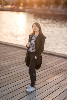 Sade bir günbatımı sahnesinde arka plandaki tarihi mimariye karşı siluet içinde duran bir kadın görülüyor. Kopenhag City, Danimarka 'da Yansıyan Kadın.