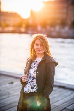 Sade bir günbatımı sahnesinde arka plandaki tarihi mimariye karşı siluet içinde duran bir kadın görülüyor. Kopenhag City, Danimarka 'da Yansıyan Kadın.