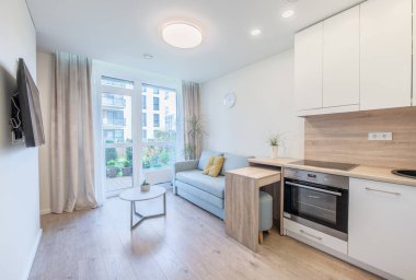 Pürüzsüz bir mutfak, rahat bir yaşam alanı ve şehir bahçesi manzaralı geniş pencereleri olan parlak çağdaş bir daire. Modern kentsel yaşamın ve verimli tasarımın mükemmel bir örneği..