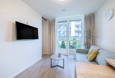 Modern mobilyaların, doğal ışığın ve çağdaş iç tasarımın sergilendiği parlak ve şık bir oturma odası. Doğal Aydınlatma ve Zarif Dekorlu Modern İskandinav Minimalist Oturma Odası.