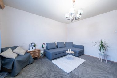 Rahat bir kanepe, zarif bir dekor ve şık mobilyalarla dolu parlak ve temiz bir oturma odası. Modern ve rahat bir ev ortamının mükemmel bir temsili..