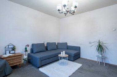 Rahat bir kanepe, zarif bir dekor ve şık mobilyalarla dolu parlak ve temiz bir oturma odası. Modern ve rahat bir ev ortamının mükemmel bir temsili..